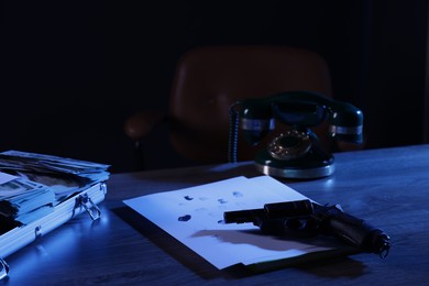 Photo of Mafia and criminal world. Gun, fingerprints, money and telephone on wooden table indoors