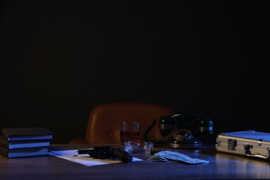 Photo of Gun, money, whiskey and other stuff on wooden table in mafia boss office