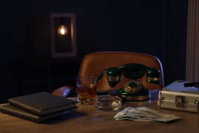 Photo of Money, whiskey and other stuff on wooden table in mafia boss office