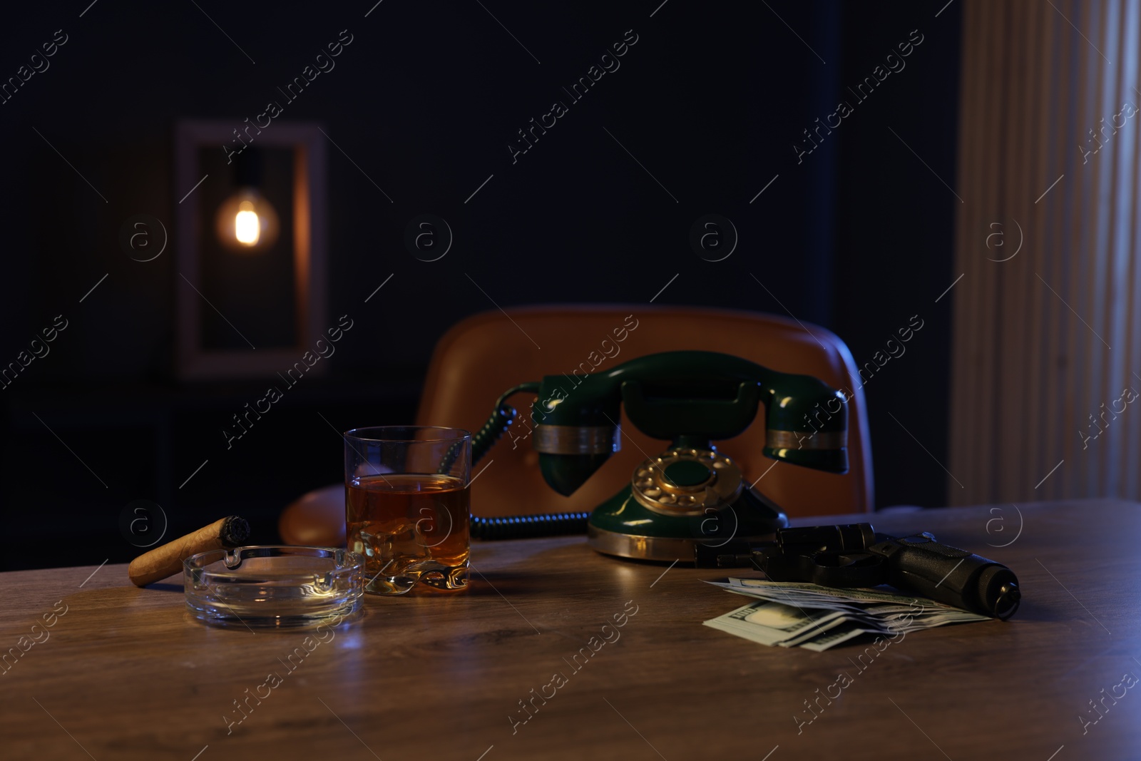 Gun, money, whiskey and other stuff on wooden table in mafia boss office Photo of Gun, money, whiskey and other stuff on wooden table in mafia boss office