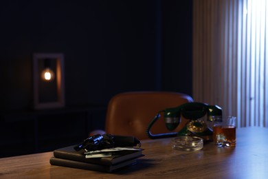 Photo of Gun, money, whiskey and other stuff on wooden table in mafia boss office