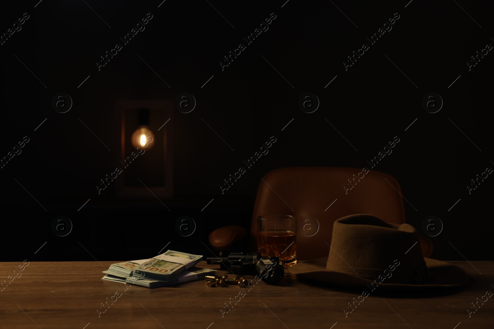 Gun, money, whiskey and other stuff on wooden table in mafia boss office. Space for text Photo of Gun, money, whiskey and other stuff on wooden table in mafia boss office. Space for text
