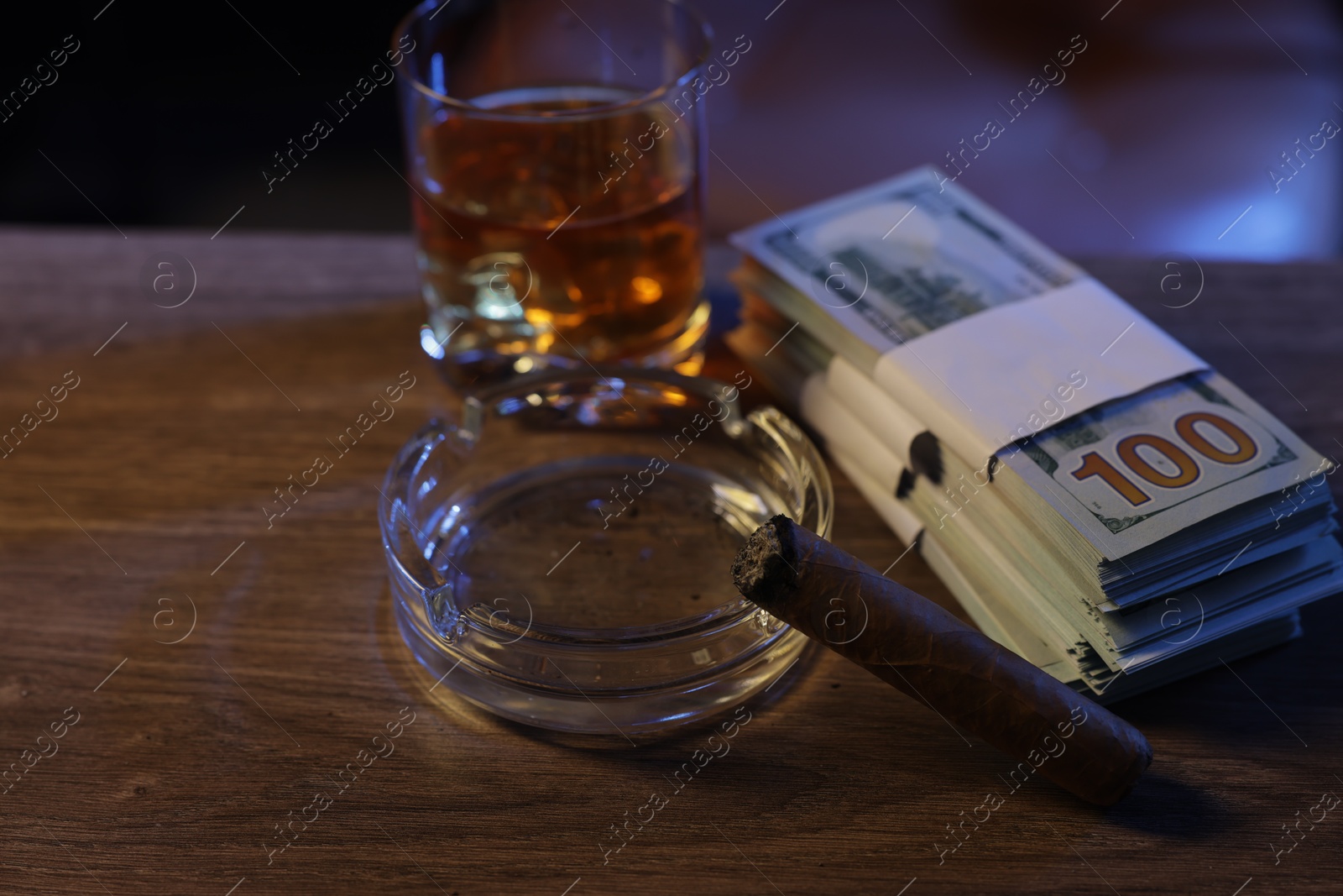 Mafia and criminal world. Ashtray with cigar, money and whiskey on wooden table, closeup Photo of Mafia and criminal world. Ashtray with cigar, money and whiskey on wooden table, closeup