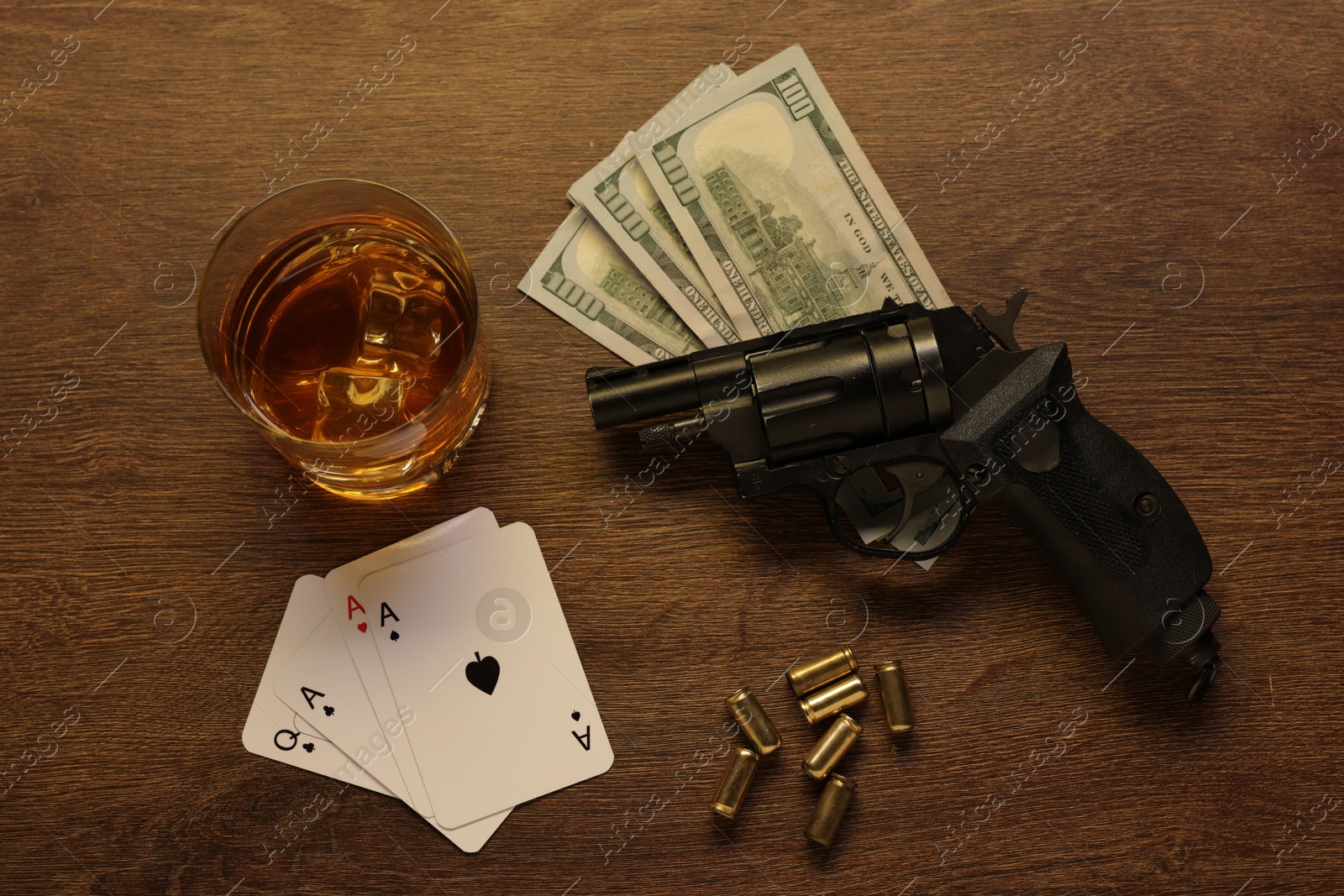 Mafia and criminal world. Gun, bullets, money, whiskey and playing cards on wooden table, flat lay Photo of Mafia and criminal world. Gun, bullets, money, whiskey and playing cards on wooden table, flat lay