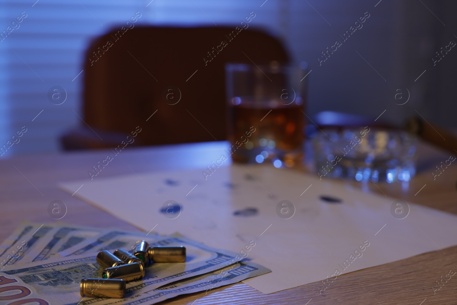 Photo of Mafia and criminal world. Money, bullets, cigar, whiskey and fingerprints on wooden table indoors, selective focus