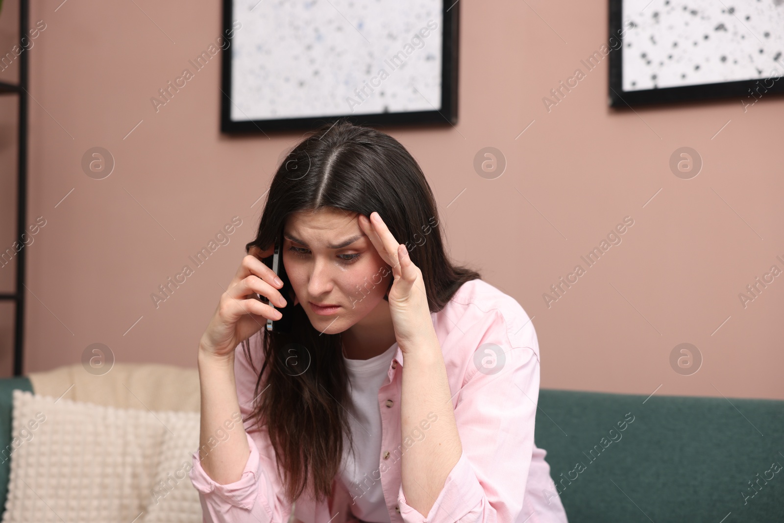 Photo of Young woman complaining to someone via phone at home