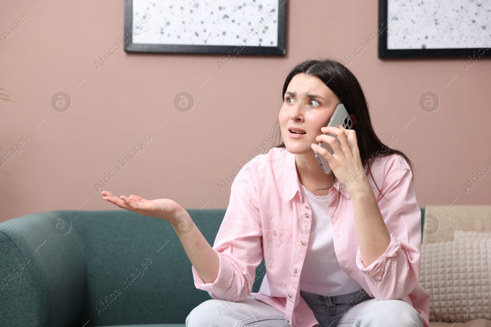 Photo of Young woman complaining to someone via phone at home