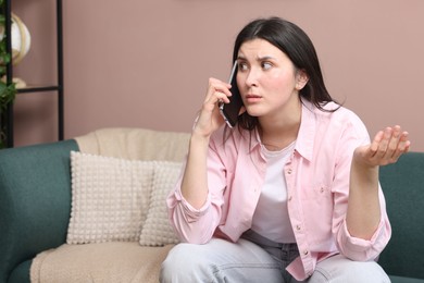 Photo of Young woman complaining to someone via phone at home