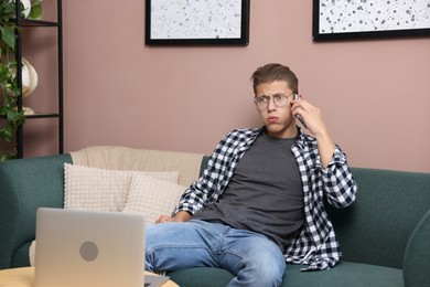 Photo of Young man complaining to someone via phone at home