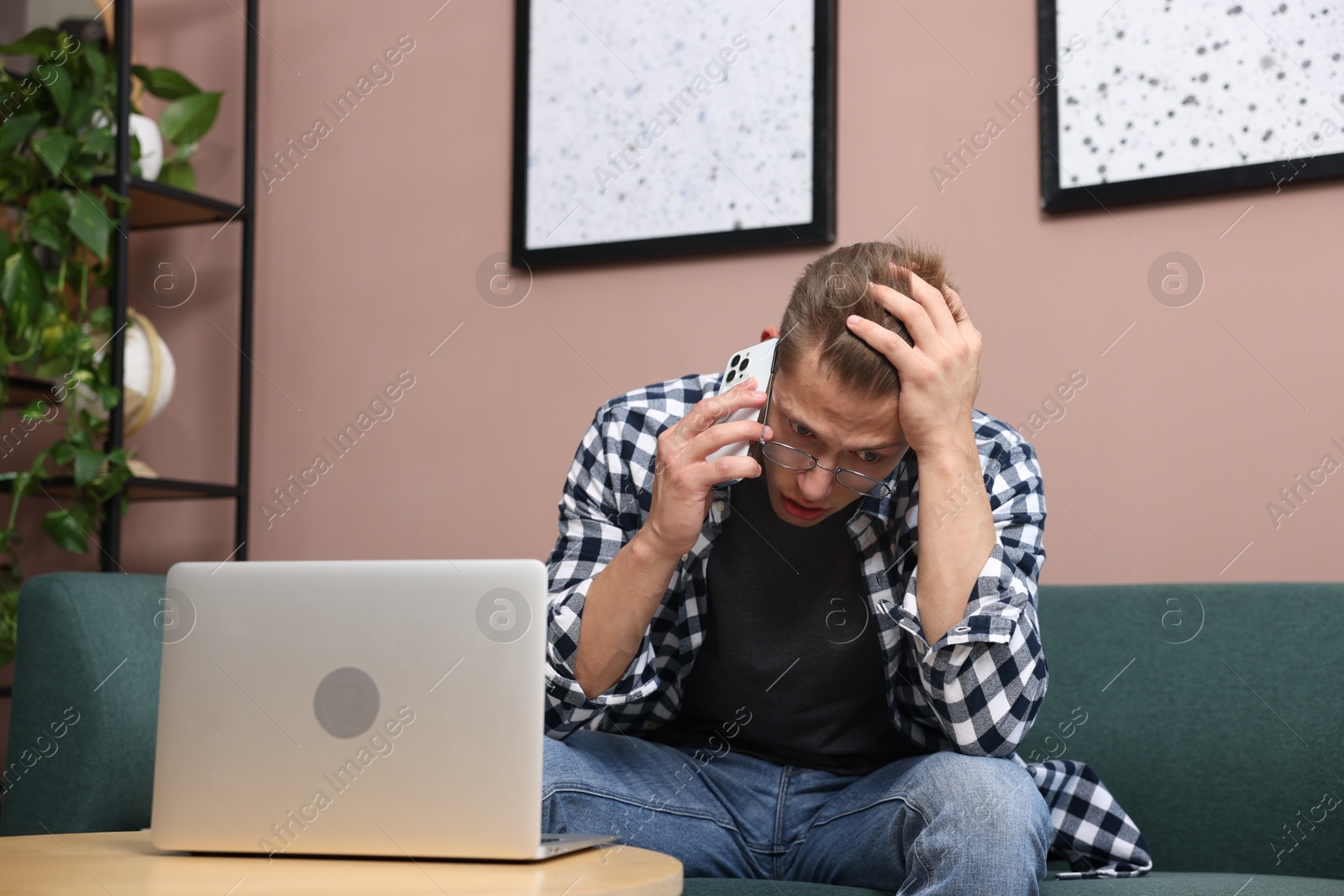 Photo of Young man complaining to someone via phone at home