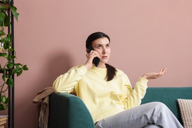 Photo of Young woman complaining to someone via phone at home