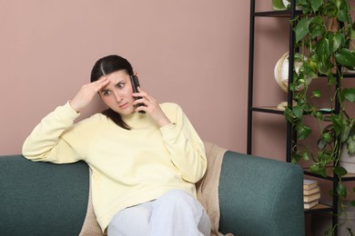Photo of Young woman complaining to someone via phone at home