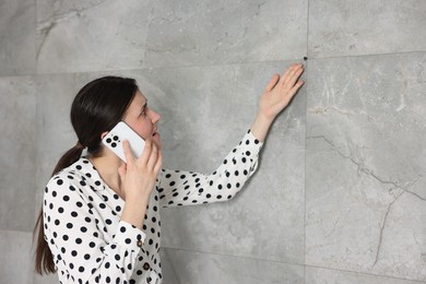 Photo of Young businesswoman complaining to someone via phone near wall indoors, space for text