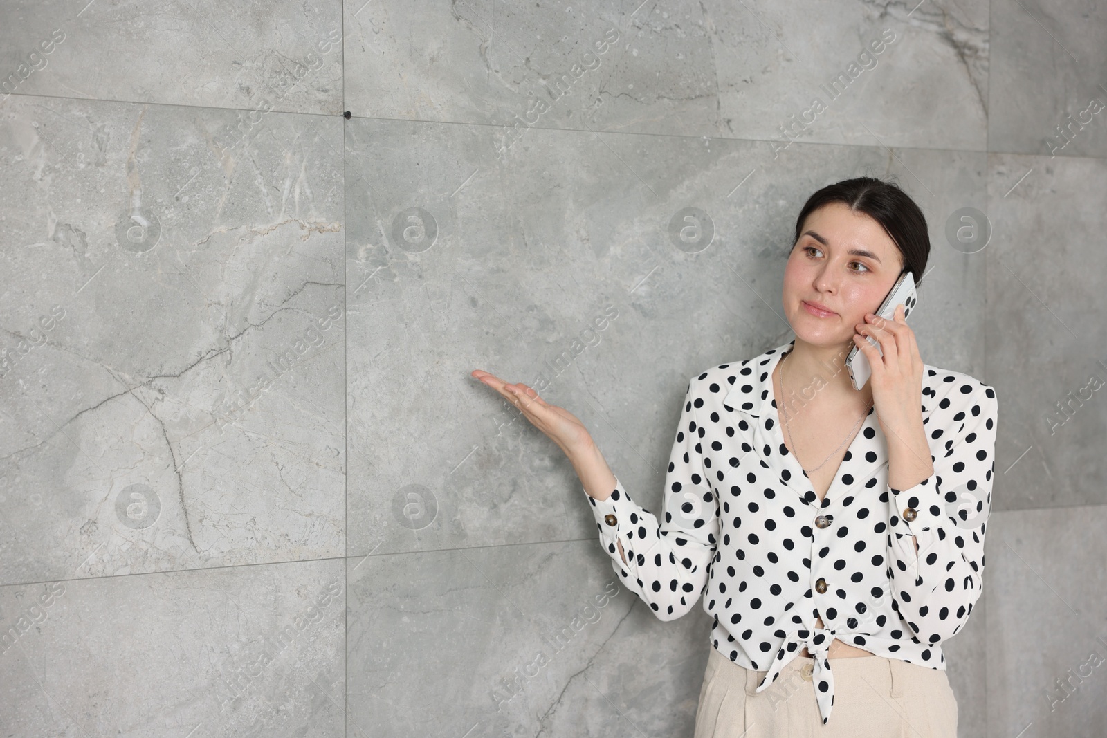 Photo of Young businesswoman complaining to someone via phone near wall indoors, space for text