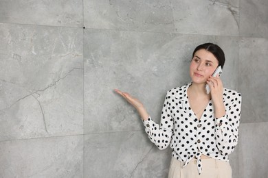 Photo of Young businesswoman complaining to someone via phone near wall indoors, space for text