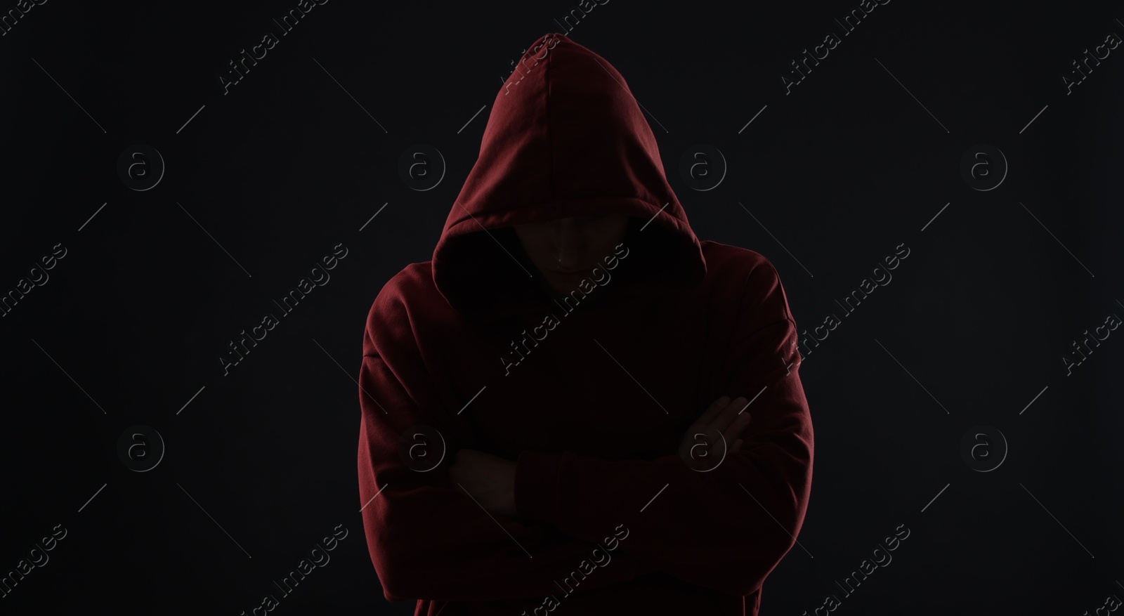 Photo of Anonymity. Man hiding his face in darkness