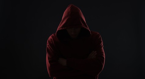 Photo of Anonymity. Man hiding his face in darkness