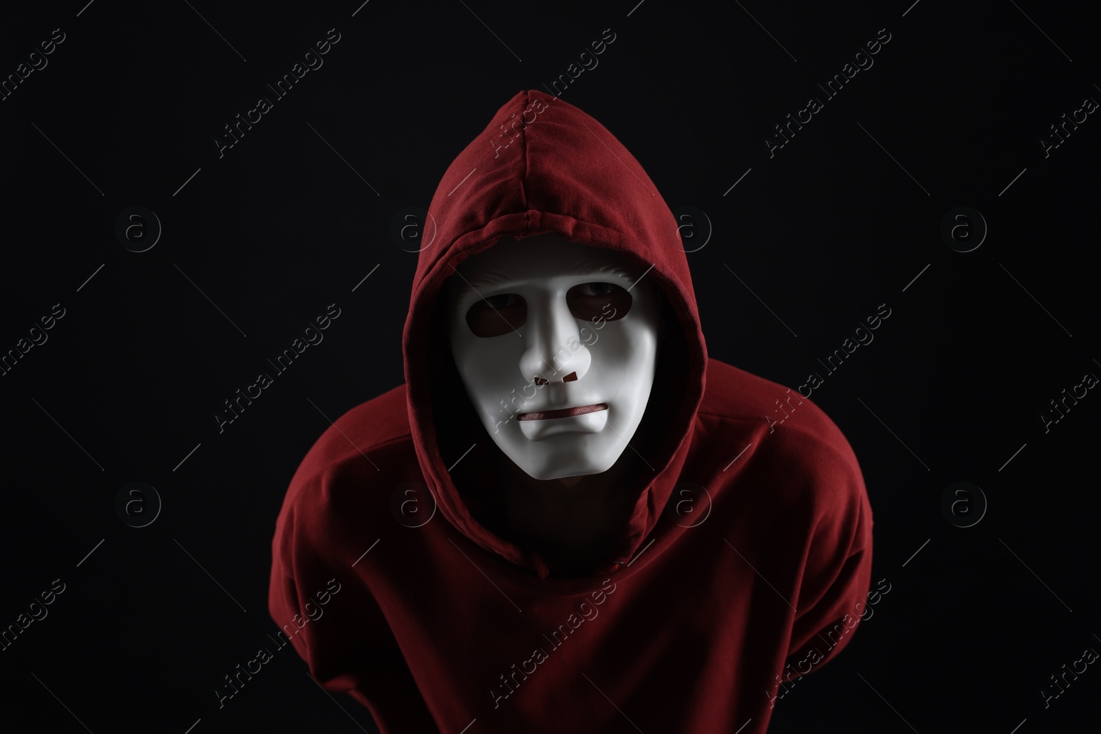 Photo of Anonymity. Man wearing mask on dark background