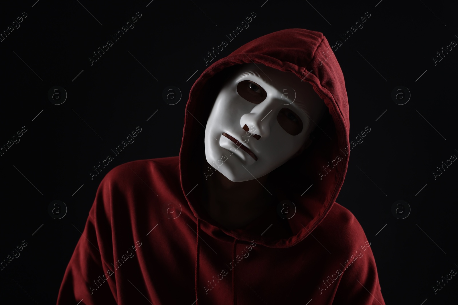 Photo of Anonymity. Man wearing mask on dark background