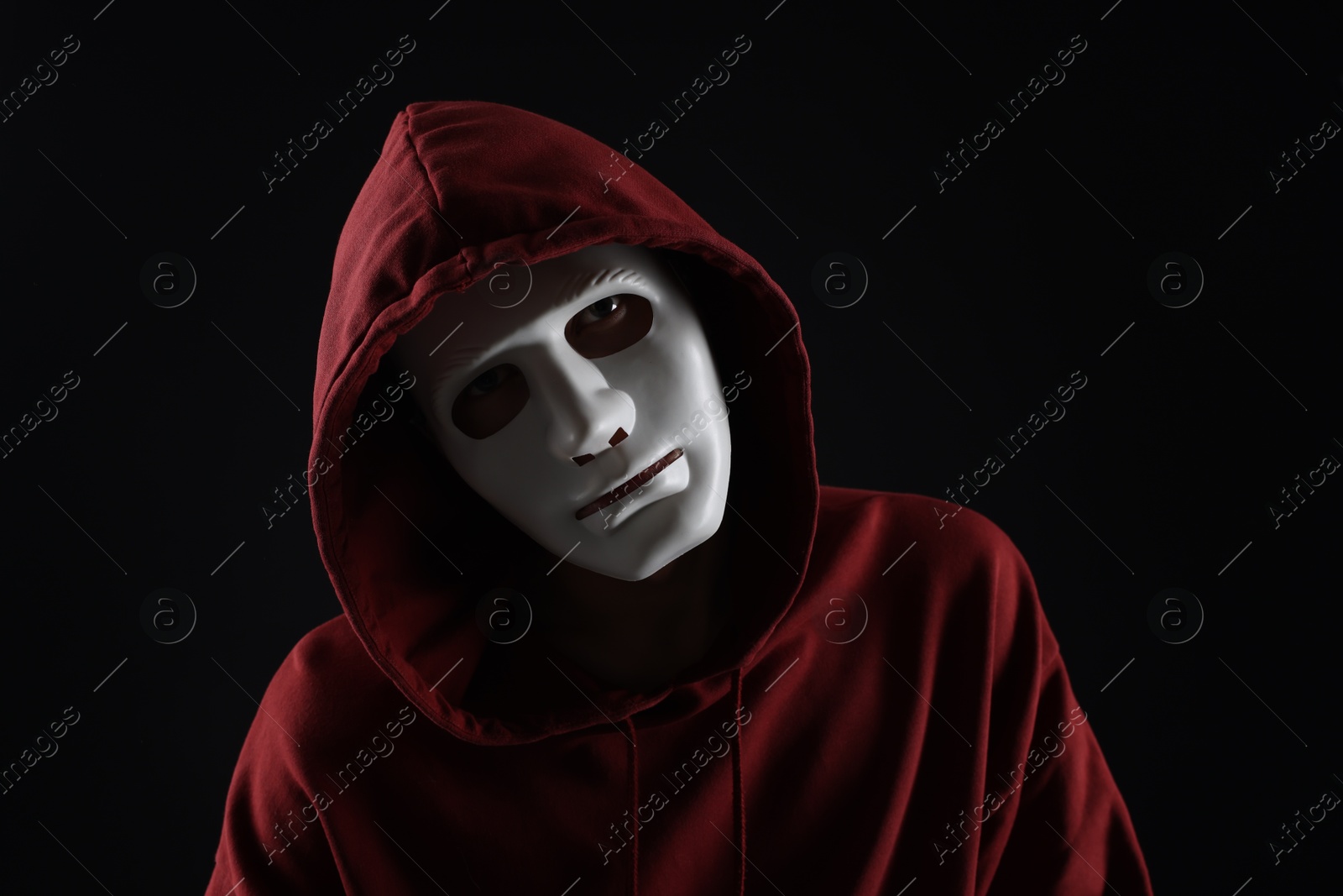 Photo of Anonymity. Man wearing mask on dark background