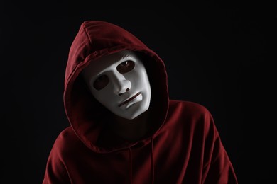 Photo of Anonymity. Man wearing mask on dark background