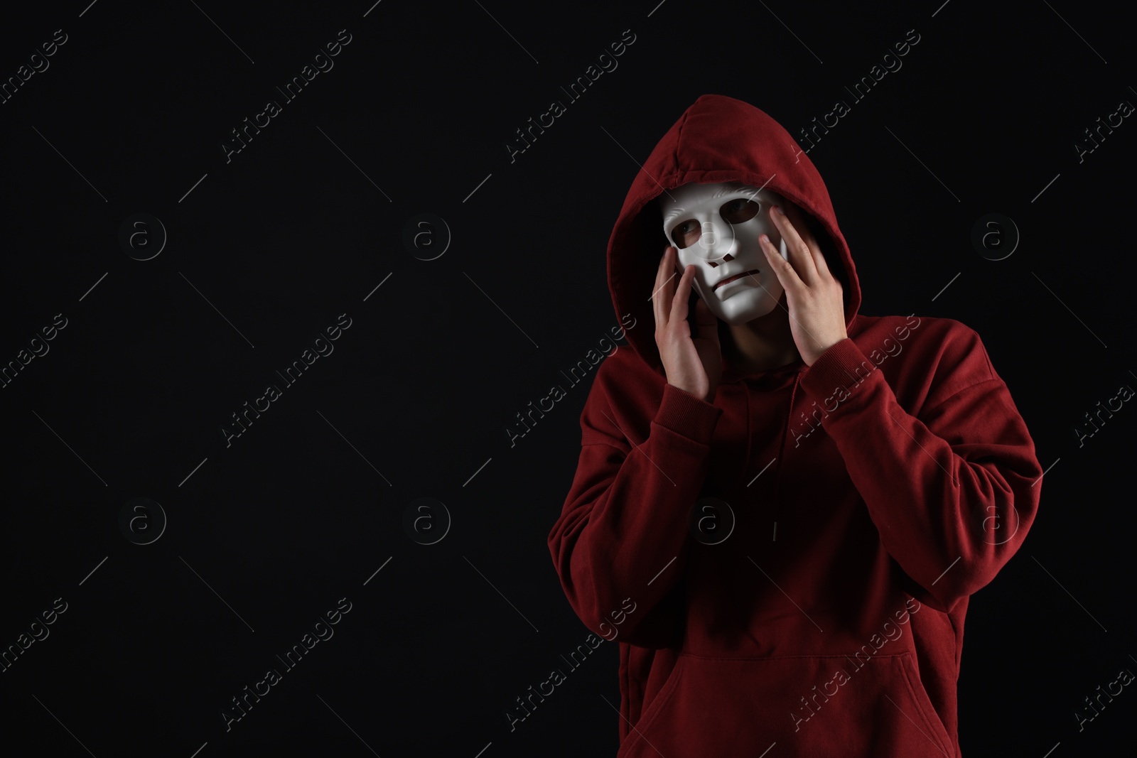 Photo of Anonymity. Man wearing mask on dark background, space for text