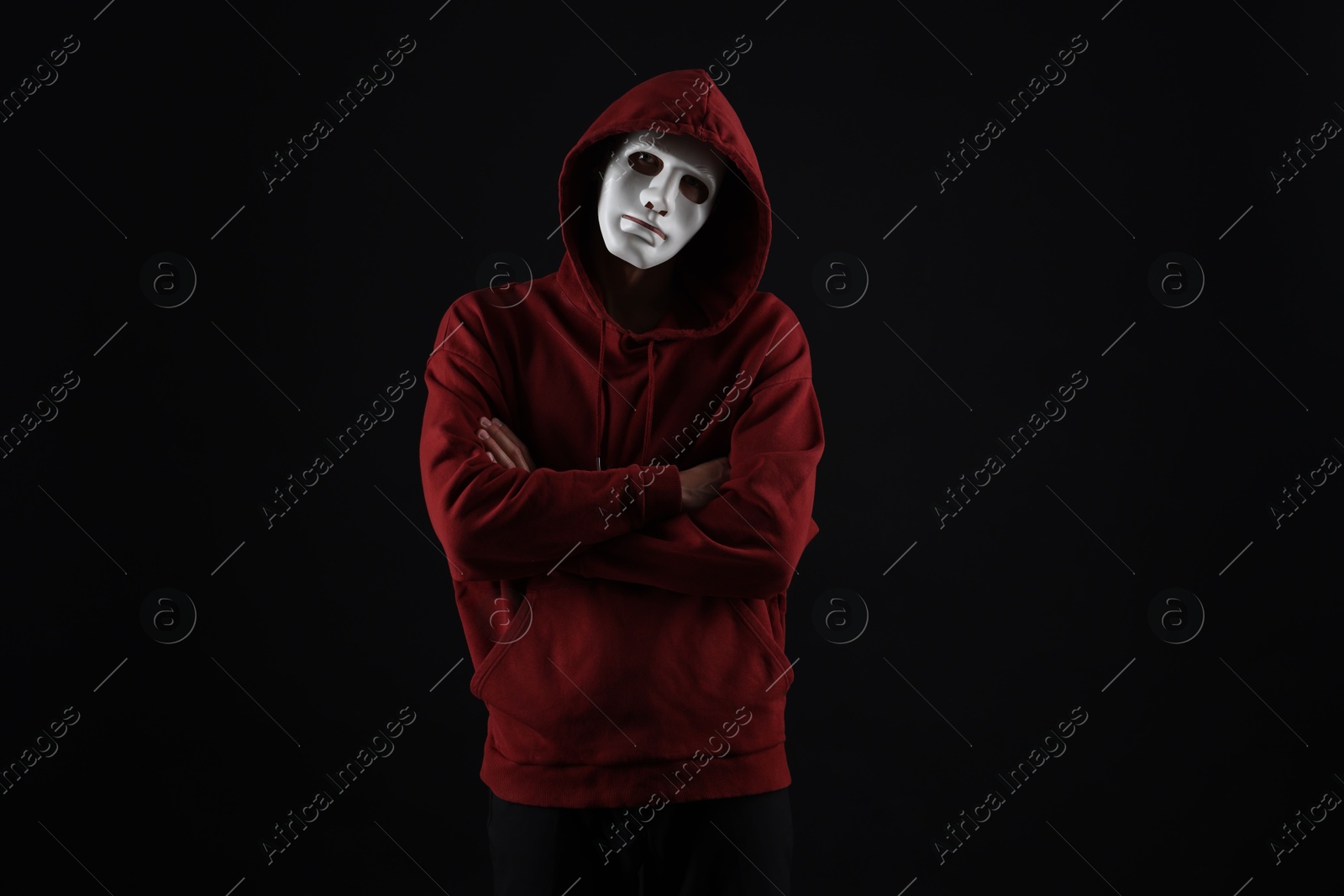Photo of Anonymity. Man wearing mask on dark background