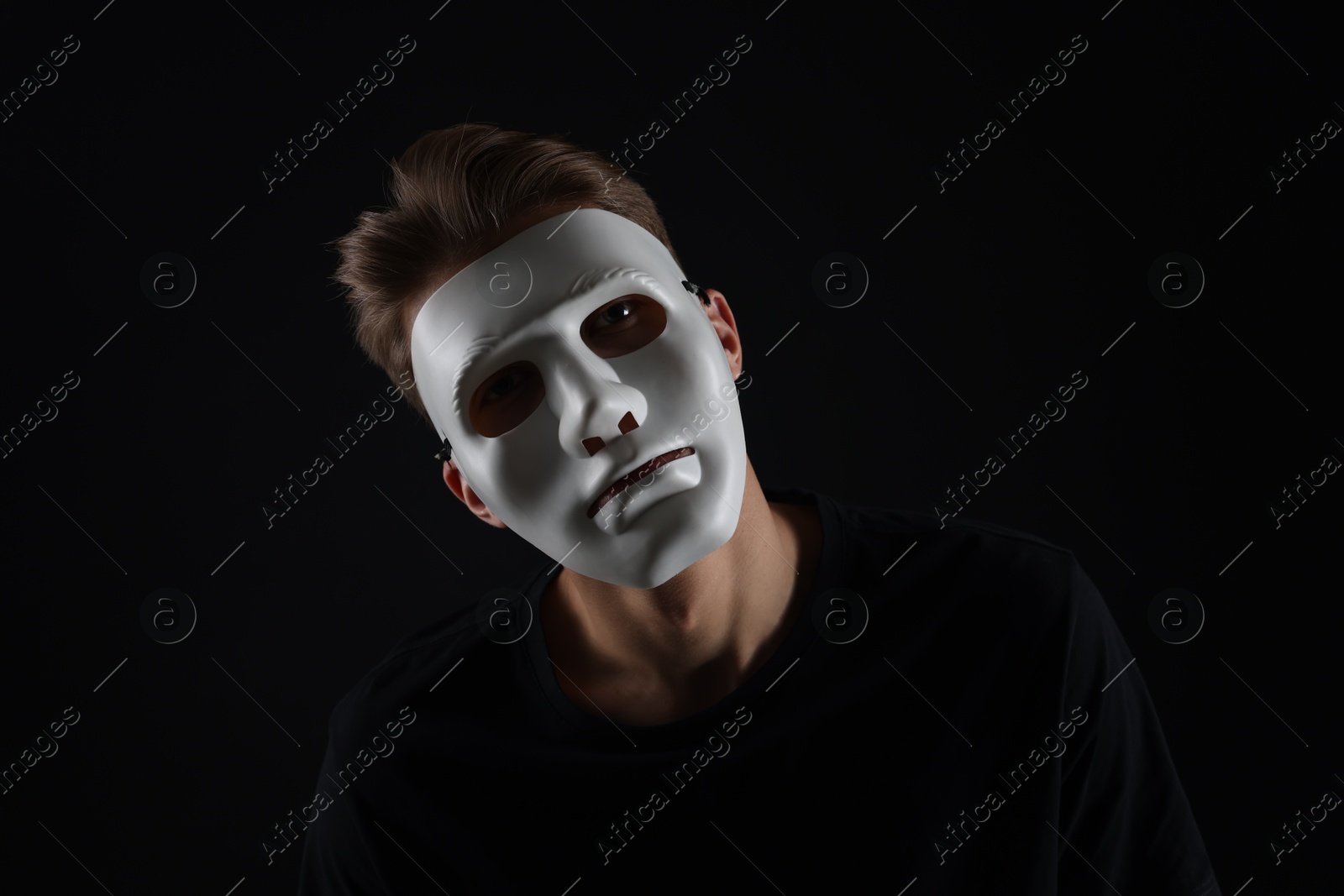 Photo of Anonymity. Man wearing mask on dark background