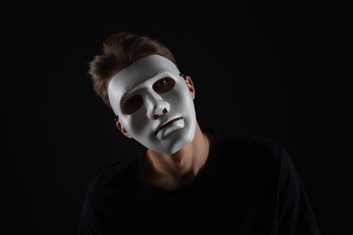 Photo of Anonymity. Man wearing mask on dark background