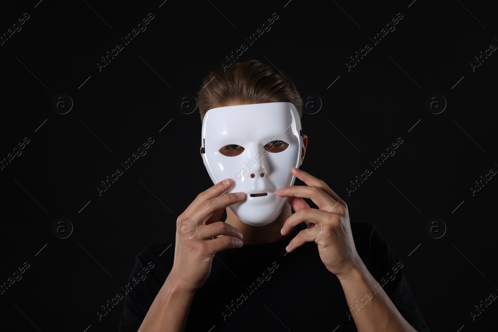 Photo of Anonymity. Man wearing mask on dark background