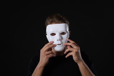 Photo of Anonymity. Man wearing mask on dark background