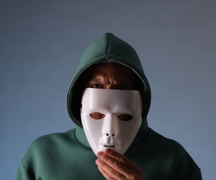 Photo of Anonymity. Man wearing mask on grey background
