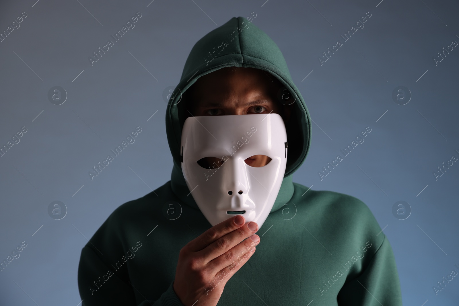 Photo of Anonymity. Man wearing mask on grey background