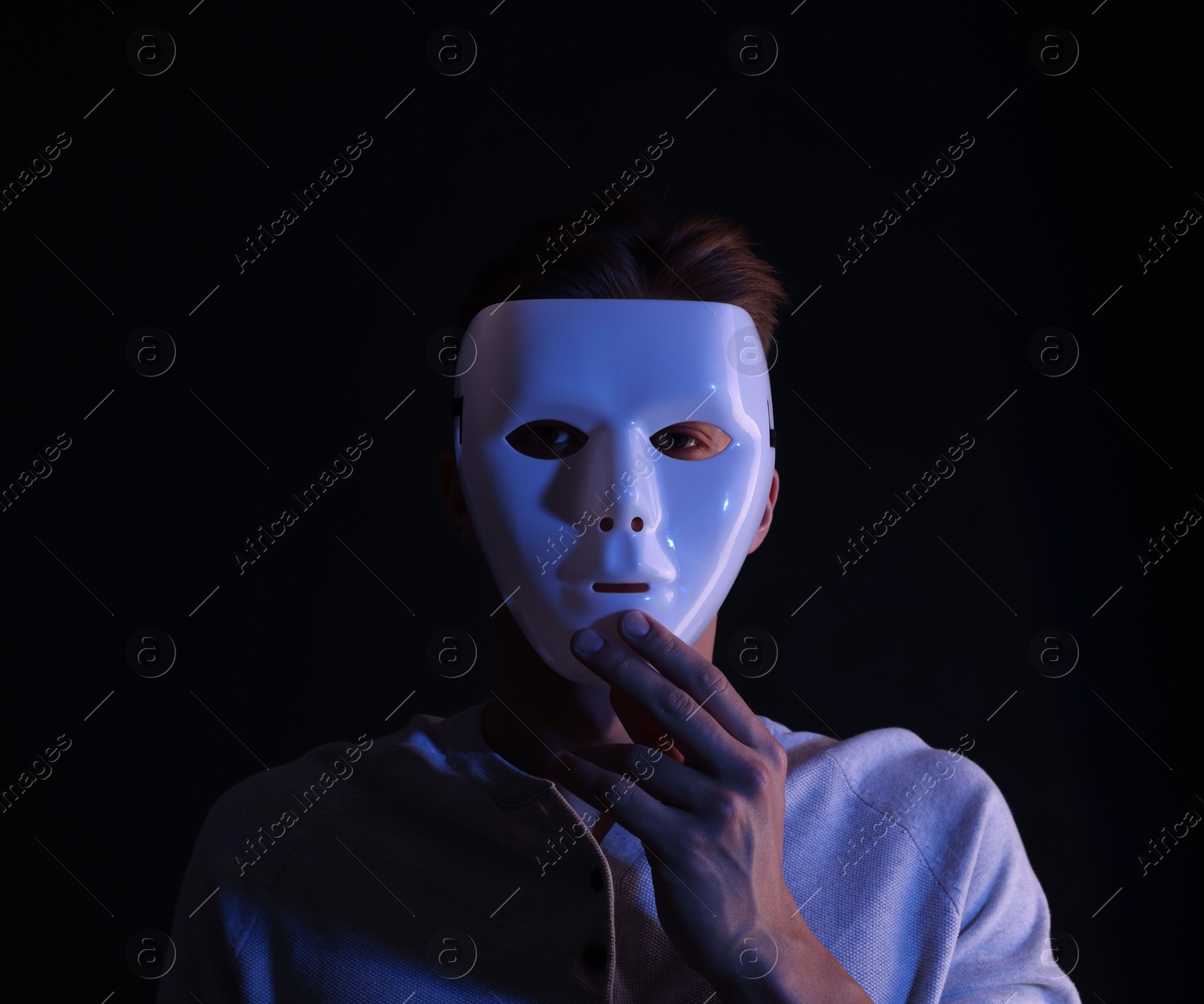 Photo of Anonymity. Man wearing mask on black background