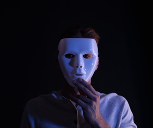 Photo of Anonymity. Man wearing mask on black background