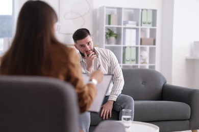 Photo of Professional psychologist working with patient in office, selective focus