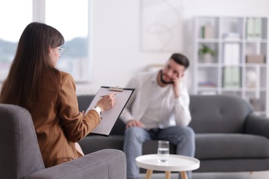 Photo of Professional psychologist working with patient in office, selective focus