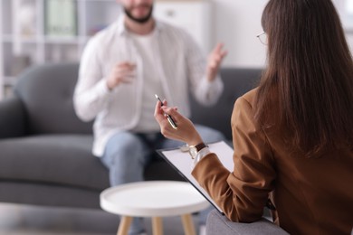 Photo of Professional psychologist working with patient in office, selective focus