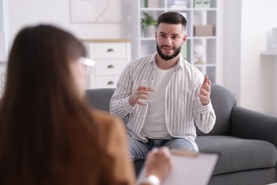 Photo of Professional psychologist working with patient in office, selective focus