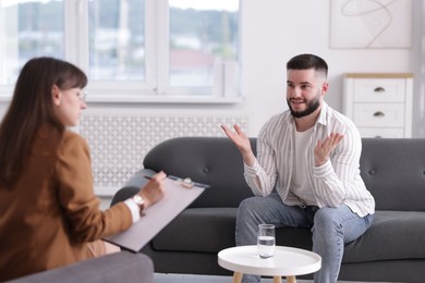 Photo of Professional psychologist working with patient in office, selective focus