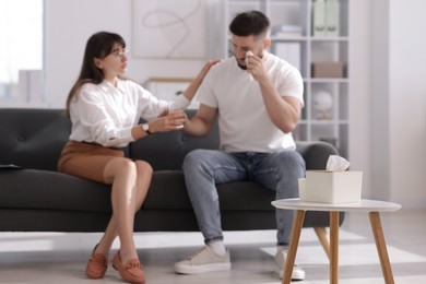 Photo of Psychologist supporting patient during therapy session on sofa in office, selective focus