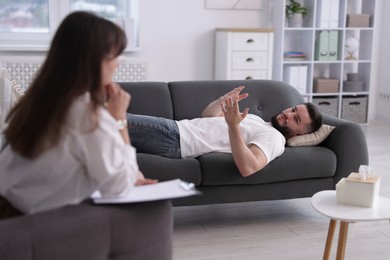 Photo of Professional psychologist working with patient in office, selective focus