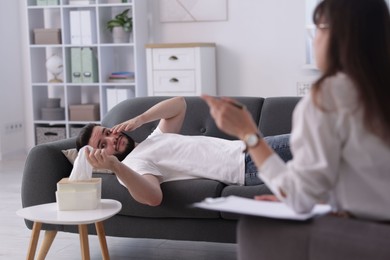 Photo of Professional psychologist working with patient in office, selective focus