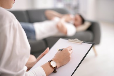 Photo of Professional psychologist working with patient in office, selective focus