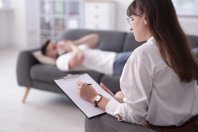 Photo of Professional psychologist working with patient in office, selective focus