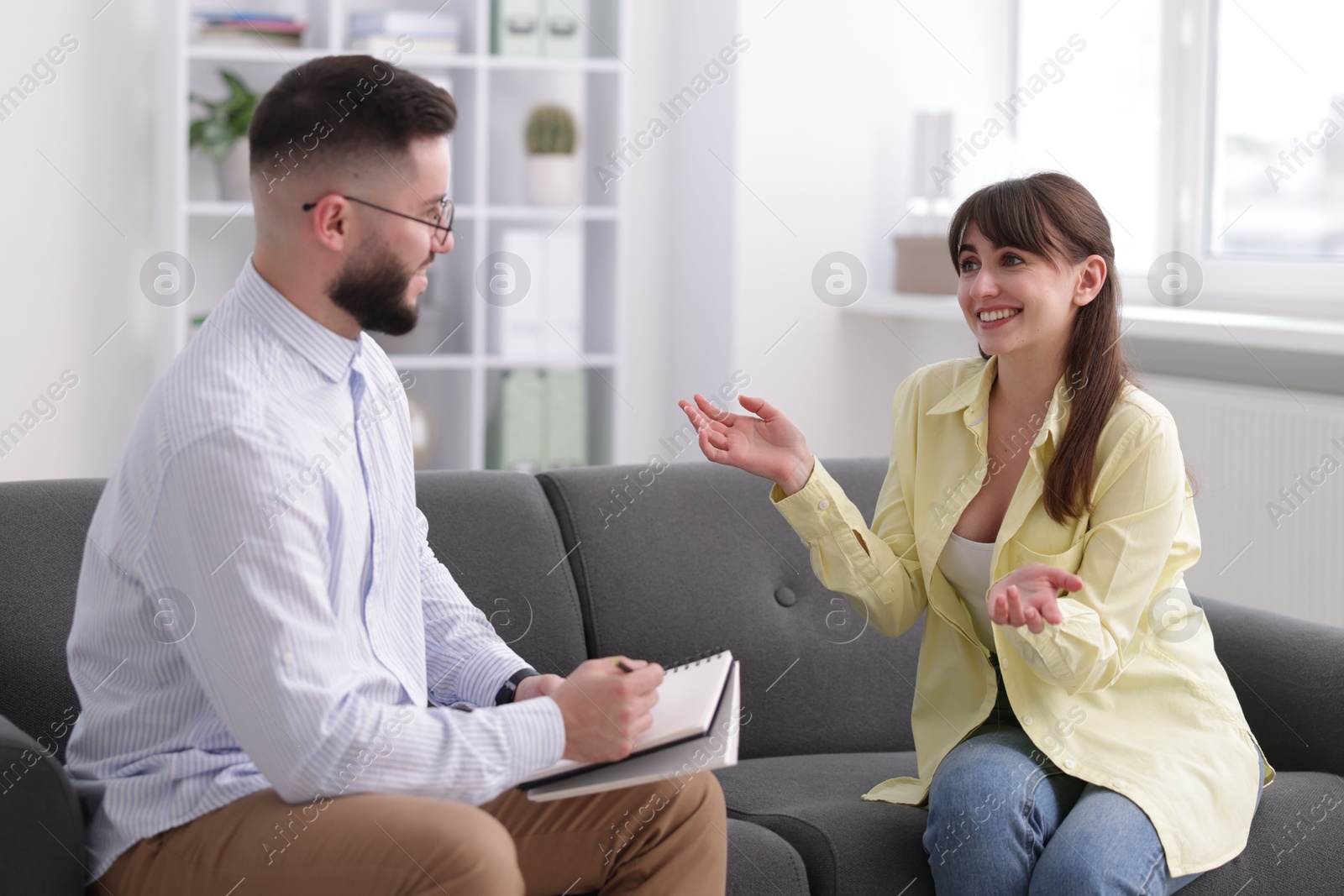 Photo of Professional psychologist working with patient on sofa in office