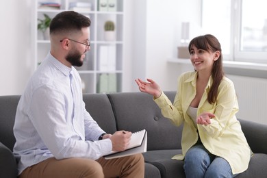Photo of Professional psychologist working with patient on sofa in office