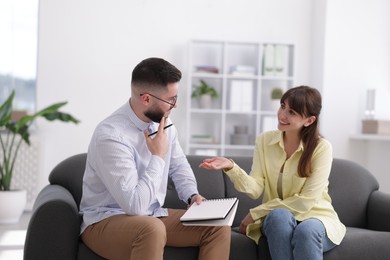 Photo of Professional psychologist working with patient on sofa in office