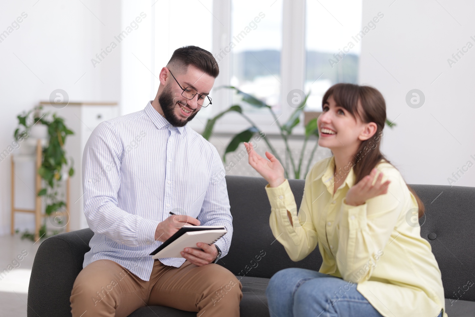 Photo of Professional psychologist working with patient on sofa in office
