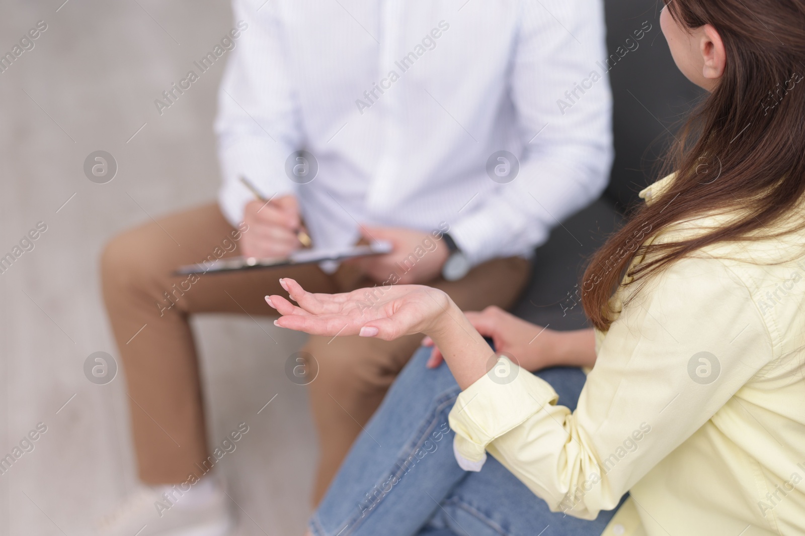 Photo of Professional psychologist working with patient on sofa in office, above view